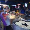 Cooks prepare chapati, a traditional Indian flatbread, for hungry market-goers 
