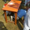 In this partner race, girls run under the table before helping each other put on accessories