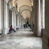 A grand hallway within the Royal Palace with people resting due to how big the palace is to walk through