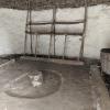 The inside of a Neolithic house with a fire pit in the center and furniture around the edges