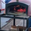 This restaurant cooks pizza in an oven on the street