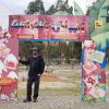 Josh stands next to the Mallasa animal sanctuary welcome sign 