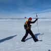 Sacha Montelli measuring the thickness of the snow on top of the sea ice using a snow probe that has a global positioning system (GPS) on top