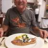 Dad enjoys scrambled eggs with thick-cut bacon for breakfast one morning