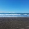 Dark sand beach and mid-rise waves in Playa Jacó, Puntarenas Province, Costa Rica