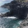 The way the waves hit the cliff has created angular volcanic pillars