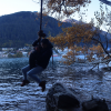 Swinging on a hanging tire in Queenstown over the lake