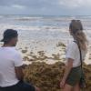 Paige and Arturo look into the horizon at a beach in Playa del Carmen