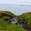 Coastal grasses around the cliffs flatten into cool patterns under the wind