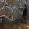 Graffiti artists use spray paint to outline the shape of Chile 
