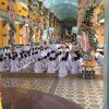 This photo was taken during a CaoDai service. The members can be seen bowing in prayer as several other members play traditional Vietnamese music. 