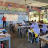 A fellow teacher instructs a class with Malaysian flags hanging over the desks (Malacca, Malaysia)