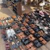 A man displays sandals of all colors, shapes and sizes in the market