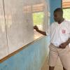 During the lesson, one student writes letters in the local language of "Dagbanli" on the white board