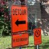 This sign lets drivers know of a detour and that they are not allowed to park in the area