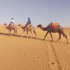 My mom and me on our camels as we walk leave camp after a night of drumming the Sahara