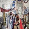 These are the traditional bride and groom outfits in India! The bride wears a red lehenga (pronounced leng-ah) with lots of jewelry, and the groom wears a white sherwani (pronounced share-wah-nee)
