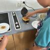 Teaching a student how to make waffles in the Food Technology classroom