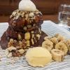 A fluffy pancake covered in melted chocolate, banana and ice cream!