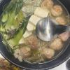 A 찌개 (jjigae), or stew, with kimchi dumplings, tofu, meat and vegetables