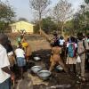 Time to water... students bring basins of water from the well pump