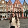 Smiling by colorful houses in Bruges, Belgium