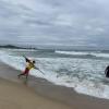 A lifeguard on the beach putting up the "no wake zone" sign