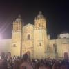 At the Zócalo, beside the illuminated Templo de Santo Domingo de Guzmán, people gathered under the night sky to have their faces painted, embracing the joy and remembrance of Día de los Muertos