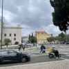 Another everyday street scene in Lisbon, with traffic, pedestrians, and city buildings in the background.