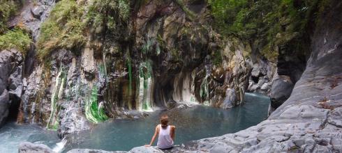 The sulfur deposits show up bright green on the rocks above the water, and right below it is the hot spring