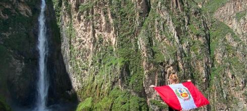 Waving the Peruvian flag in front of a waterfall