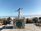 Me on a structured pile of rocks with a plaque reading that I'm standing on Africa’s southernmost point...east of this is the Indian Ocean and west is the Atlantic Ocean