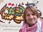 Here's a photo next to some colorful Arabic writing; the geometric nature of the language makes it great for art or graffiti