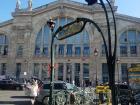 An entrance to the Paris subway, with the train station in the background