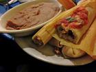 A tamale served with salsa and refried beans (Photo from Flickr)
