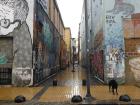 A graffiti-covered alley in the rain