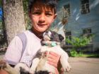A boy holds his sheepdog puppy, Rocky. Tajik dogs are very loyal.