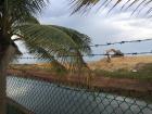 A backhoe redistributes sand, reconstructing the beach after a storm