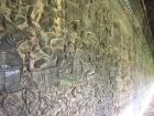 Ornate carvings of historical scenes adorn temple walls at Angkor Wat