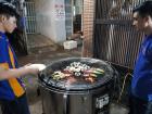 Workers at the restaurant cooking oysters over the grill