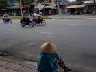 Vietnamese woman watching the motorbikes drive by