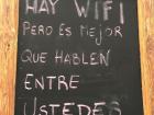 The sign reads "There is WiFi, but it's better to speak with each other". Thought it was funny