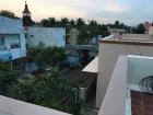 From the roof, there is a great view of the coconut trees on the horizon.  Do you see the little neighborhood temple?