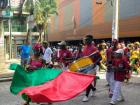 A woman leads her parade group, proudly waving the flag of Quibdó