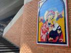 A mural of the Virgin Mary holding baby Jesus with a soccer ball outside the metro station nearest the local stadium