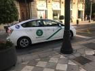 A taxi waiting near a plaza for customers