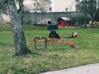 A gardener sweeps up the last of the fall leaves