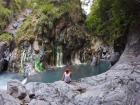 The sulfur deposits show up bright green on the rocks above the water, and right below it is the hot spring