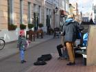 A little girl dances with a street musician band