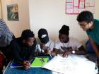Helping migrants read words of encouragement from university students